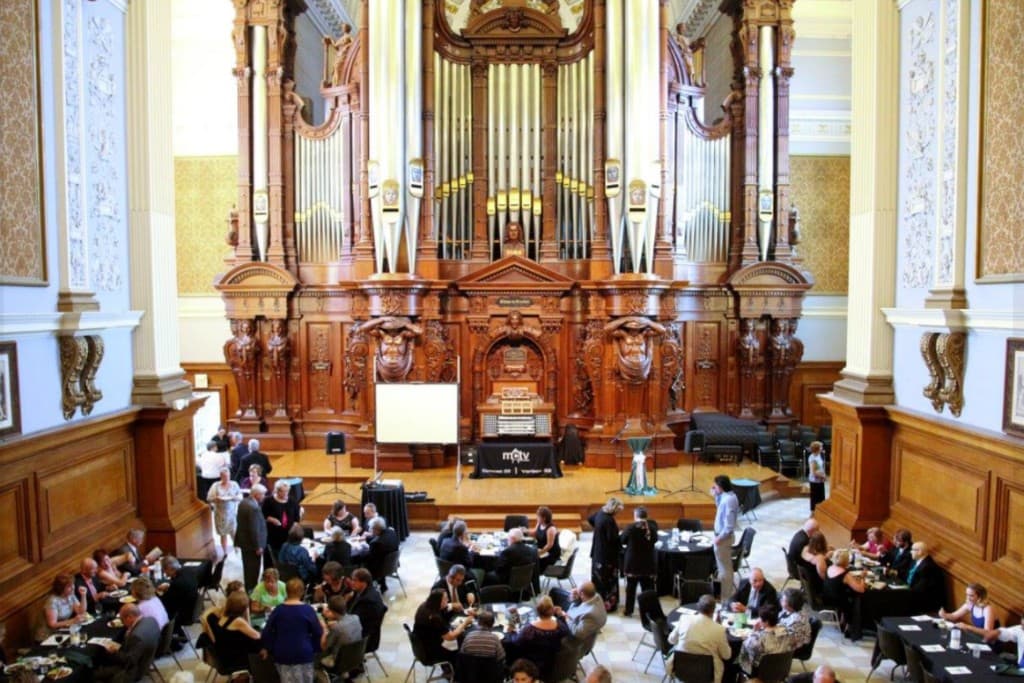 Guests at a formal dinner in Methuen Memorial Organ Hall with the historic pipe organ